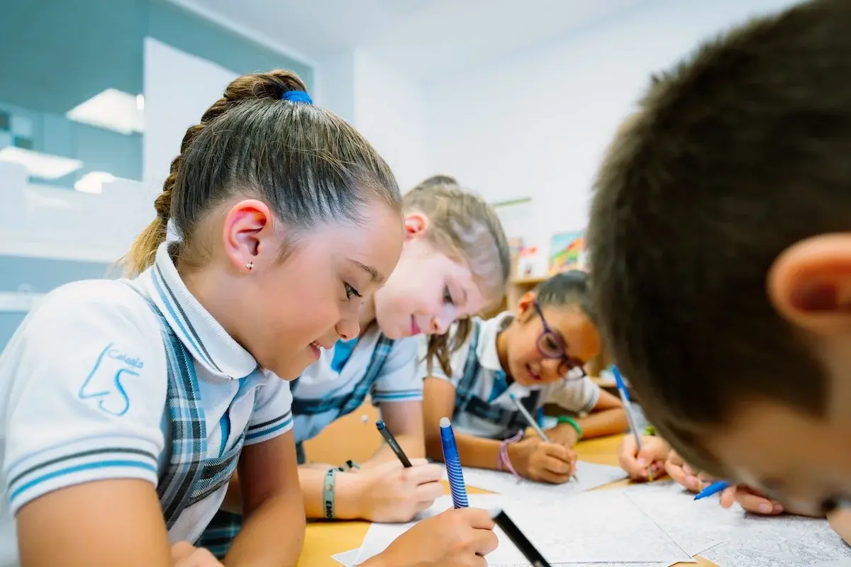 Estudiantes del Liceo Sorolla escribiendo en sus cuadernos durante una clase en el aula