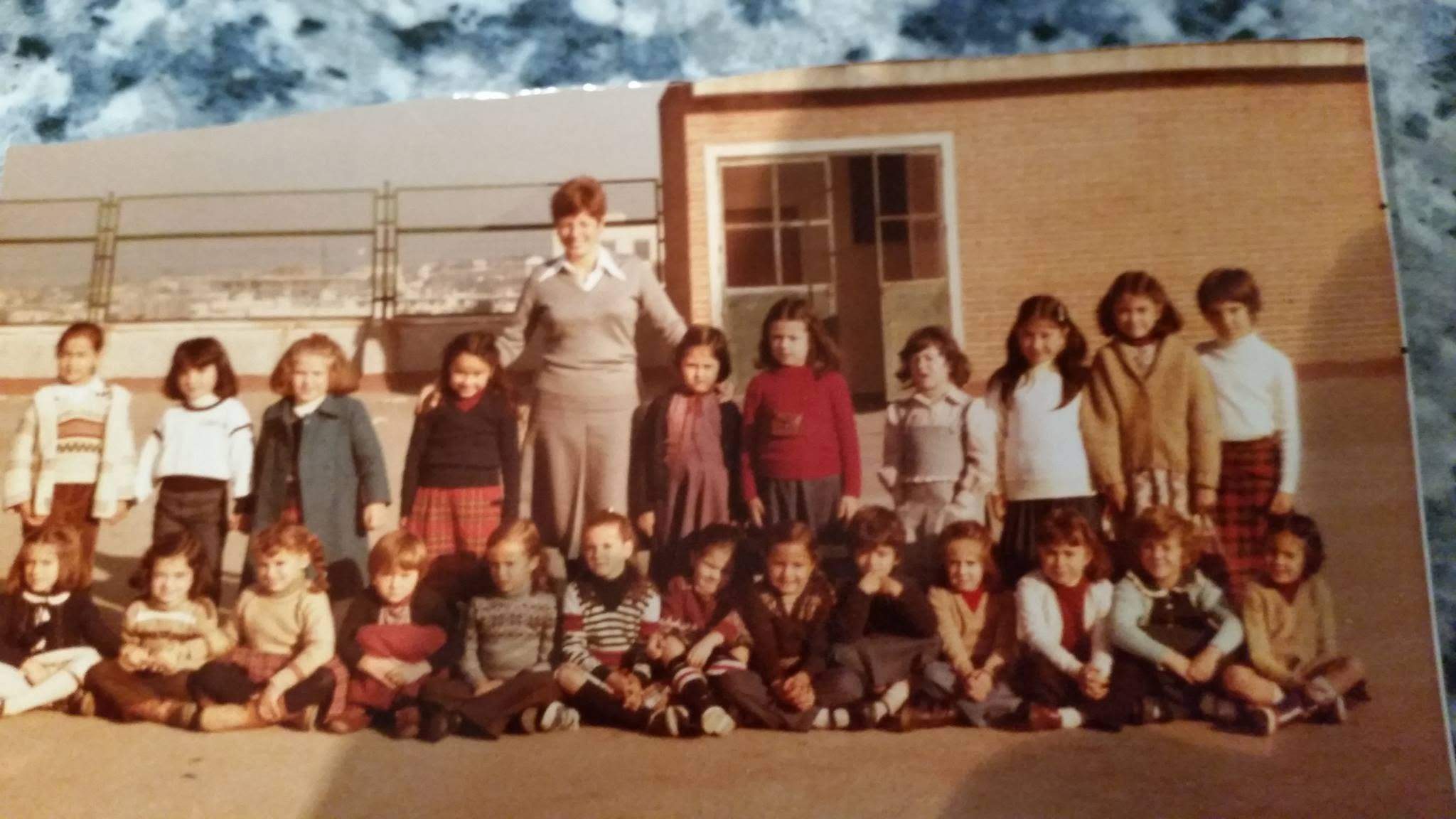 Grupo de estudiantes y docente en formación frente a edificio escolar del Liceo Sorolla en fotografía vintage