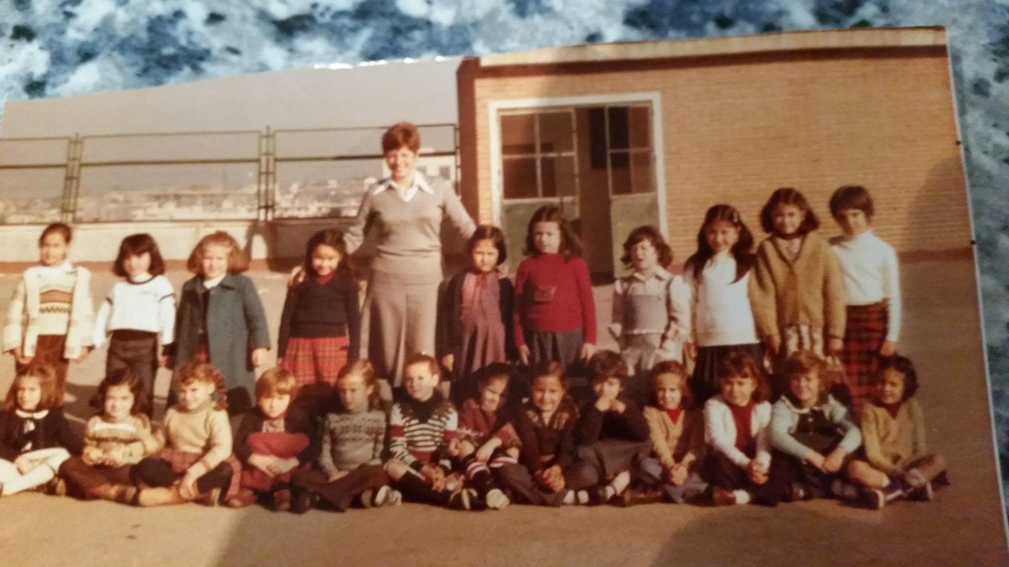 Grupo de estudiantes y docente en formación frente a edificio escolar del Liceo Sorolla en fotografía vintage