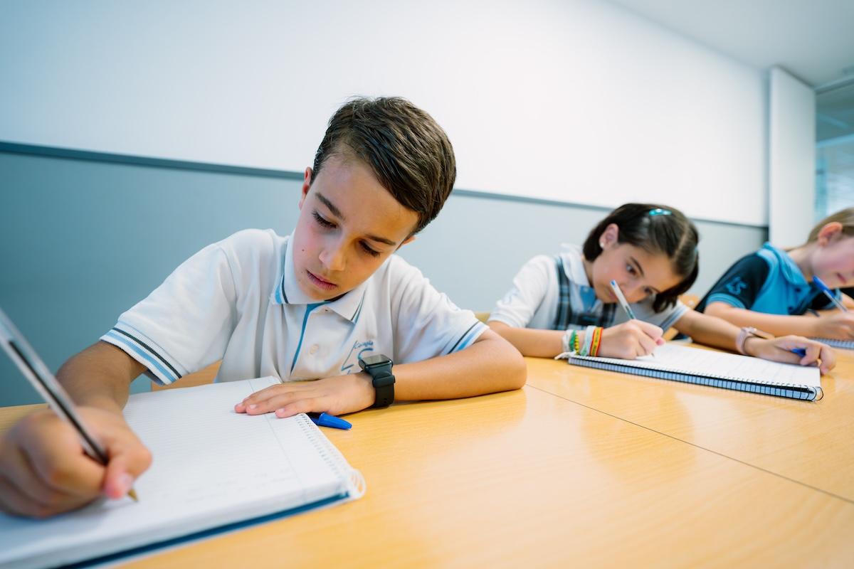 Estudiantes escribiendo en cuadernos durante una clase en el aula del Liceo Sorolla